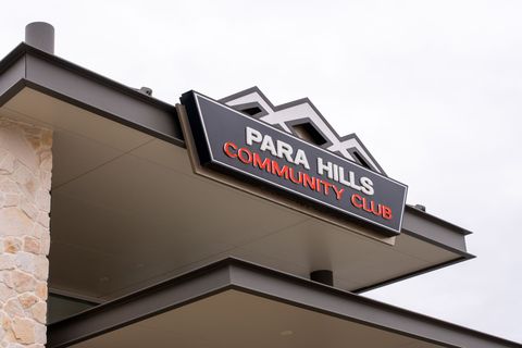 A group of children are sitting in front of a large screen watching a show at Para Hills Community Club