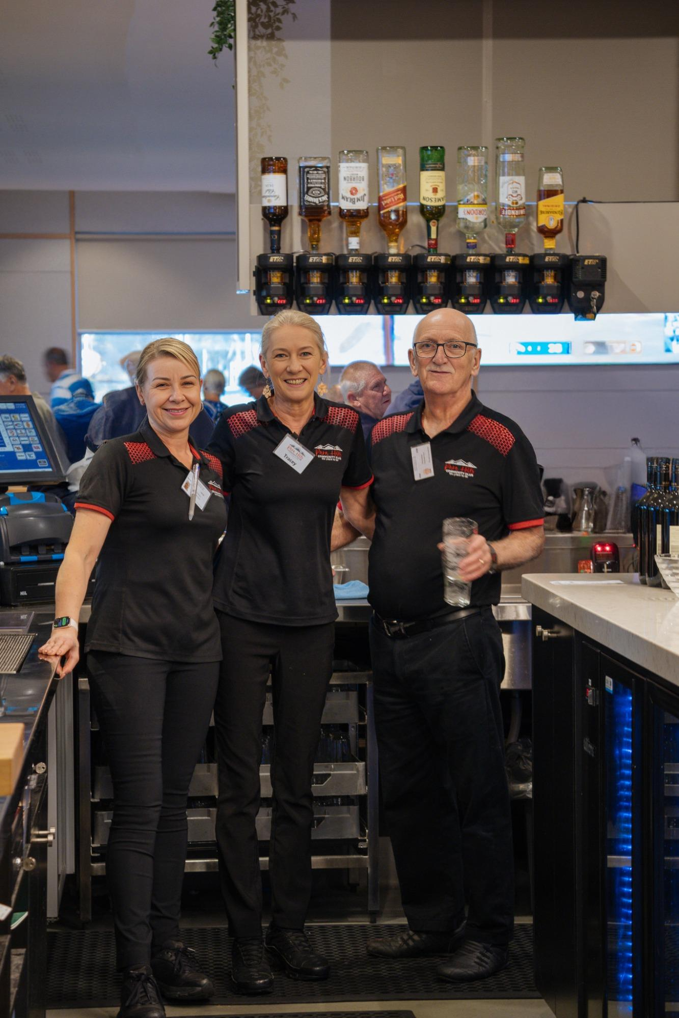 A man is standing behind a bar taking a picture of a beer tap at Para Hills Community Club