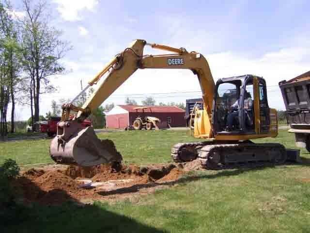 Excavator digging the land - Septic Tank Cleaning Residential