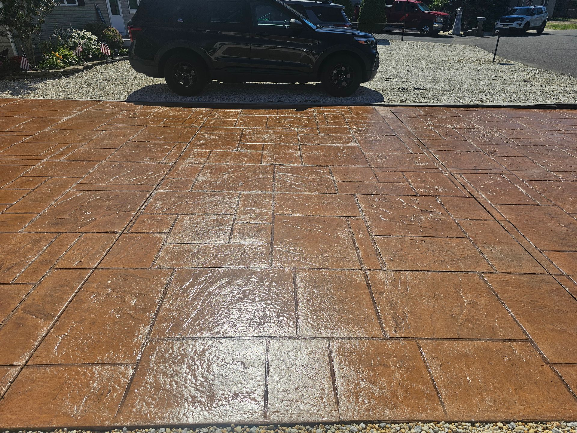 A black suv is parked on a brick driveway.