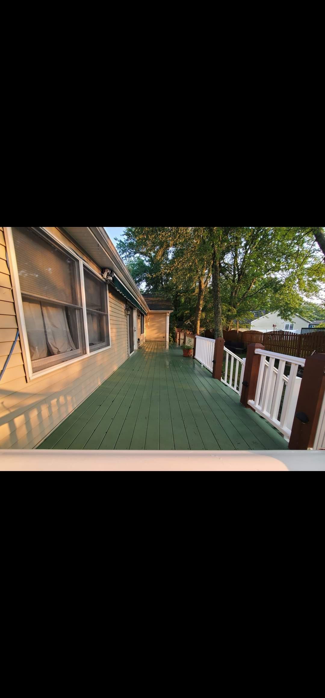 A long walkway leading to a house with a white railing.