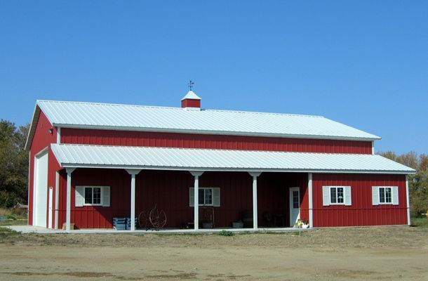 A large red barn with a white roof and porch