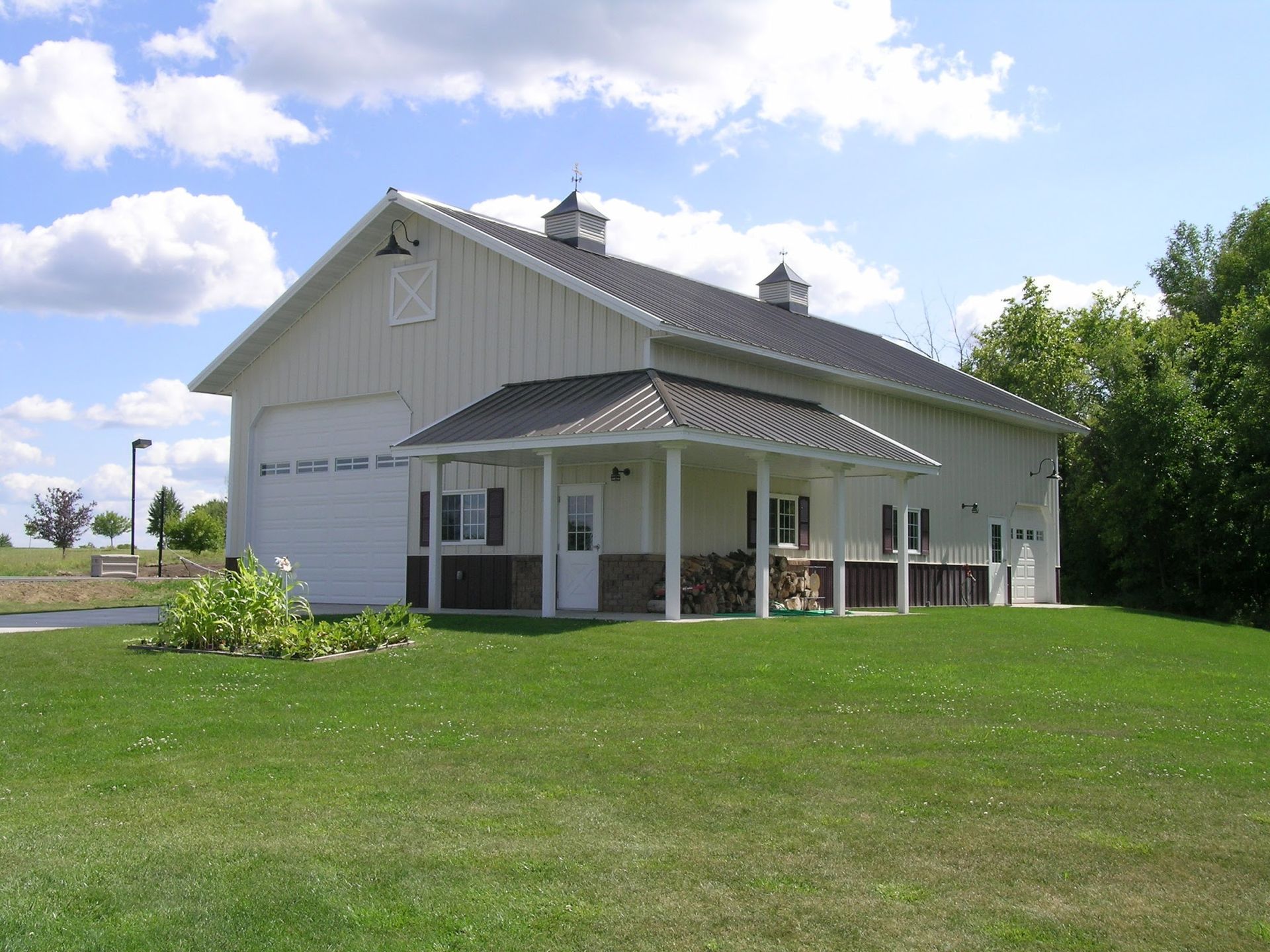 A large white barn with a porch and a garage