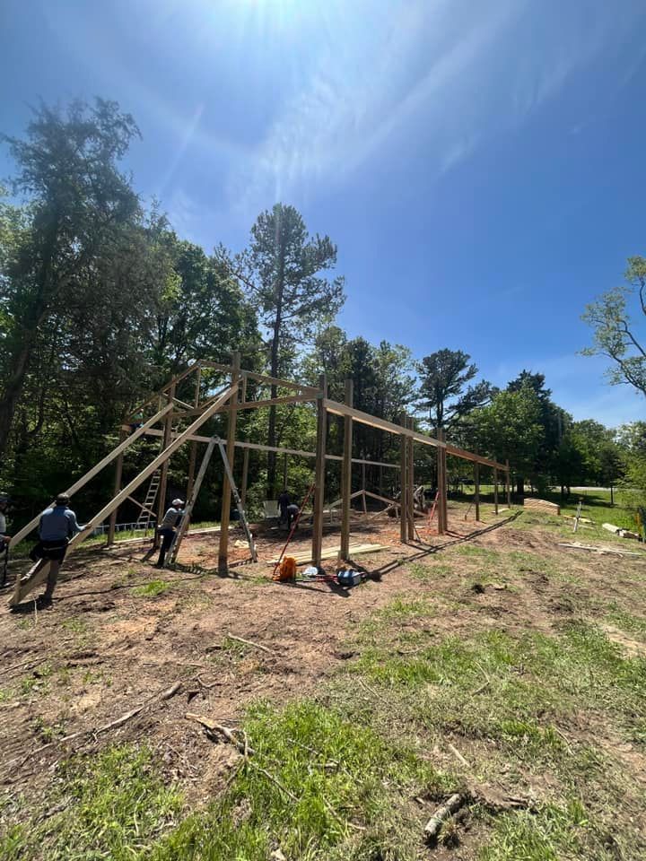 A group of people are working on a wooden structure in a field.