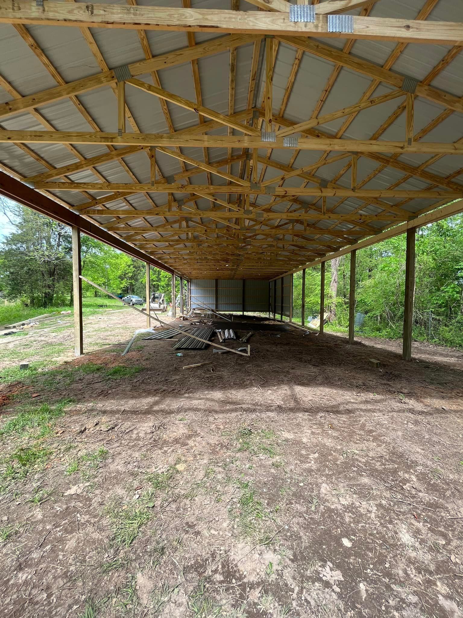 A large wooden structure is being built in the middle of a dirt field.