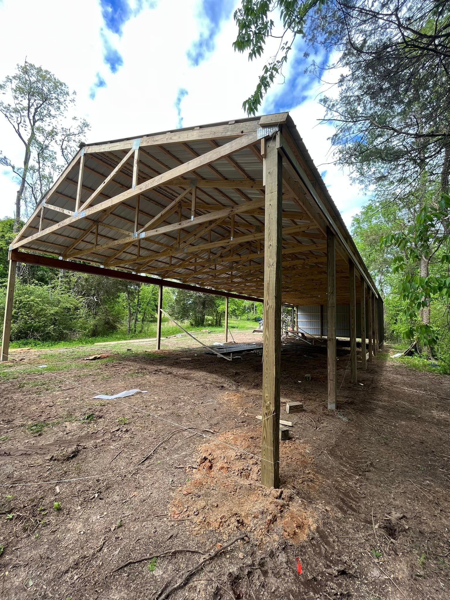 A large wooden structure is sitting in the middle of a dirt field.