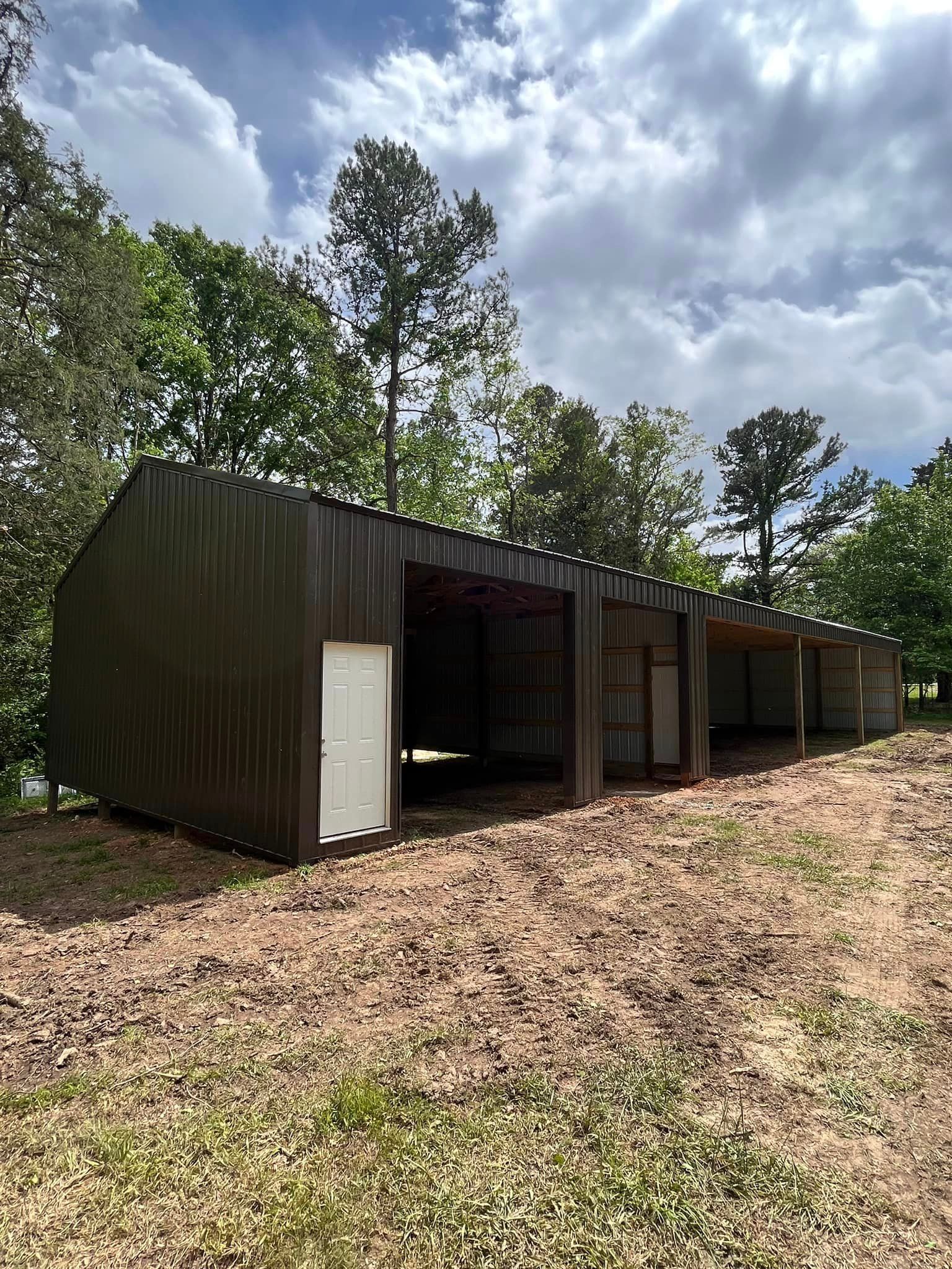 A row of sheds are sitting on top of a dirt field.