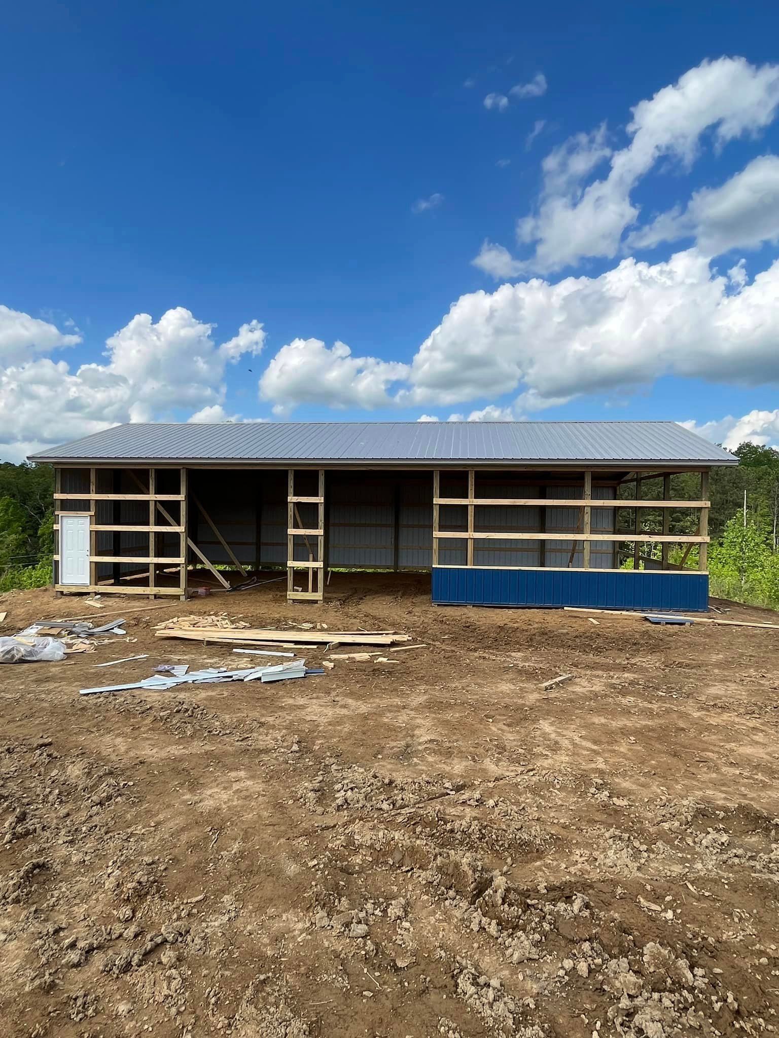 A large building is being built in the middle of a dirt field.