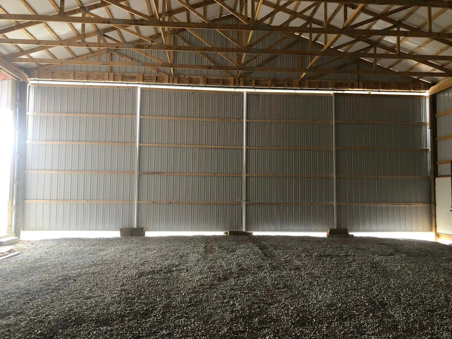 The inside of a barn with a large sliding door.