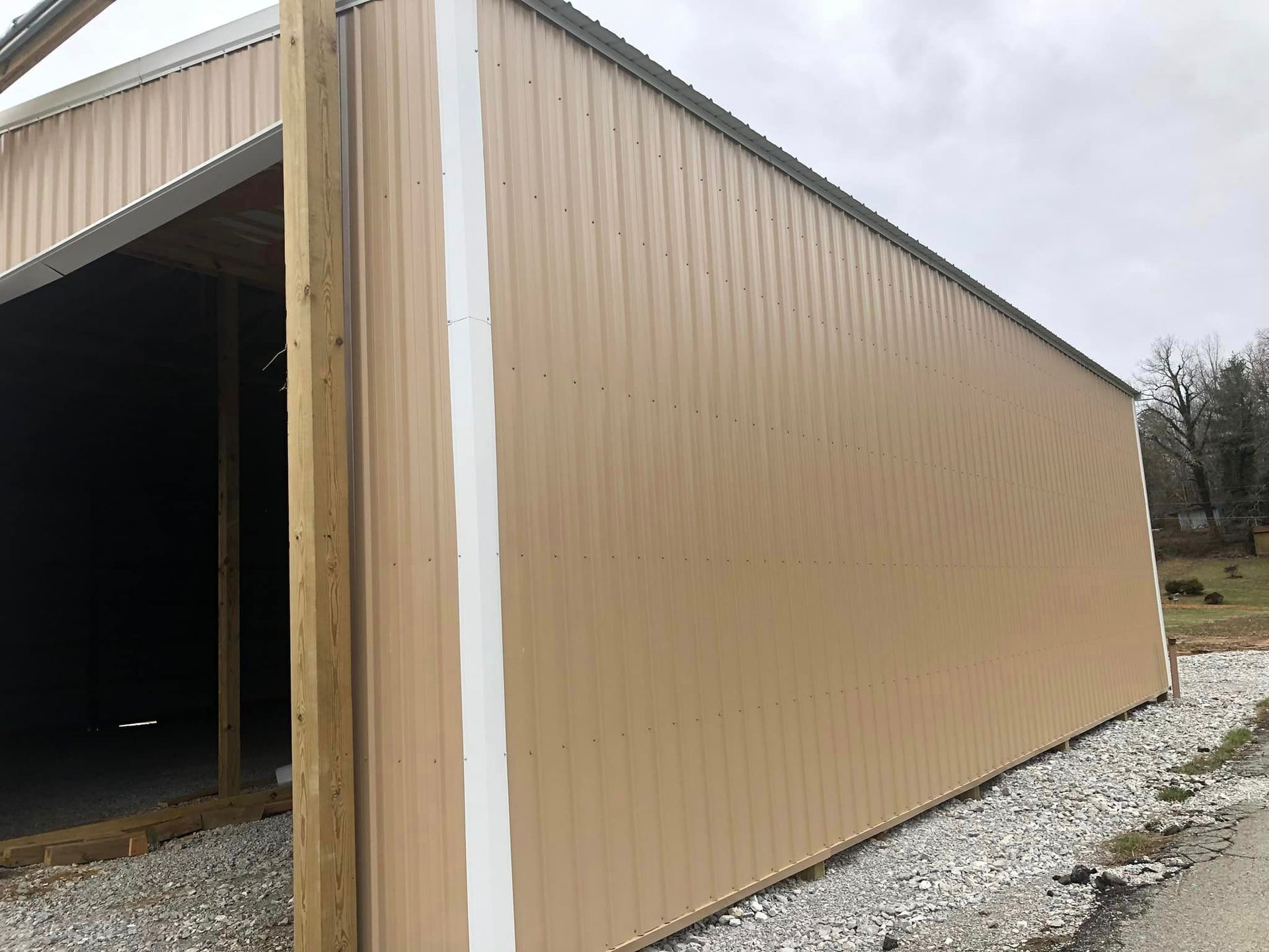 A large tan metal building with a white stripe on the side.