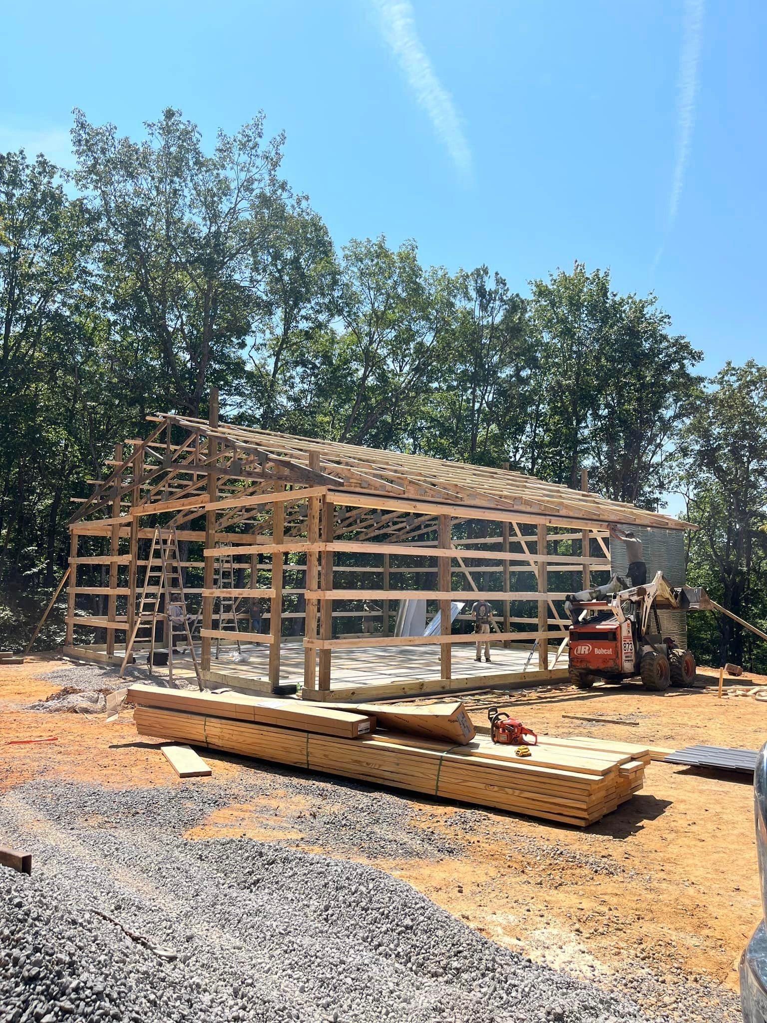 A large wooden structure is being built in a dirt field.