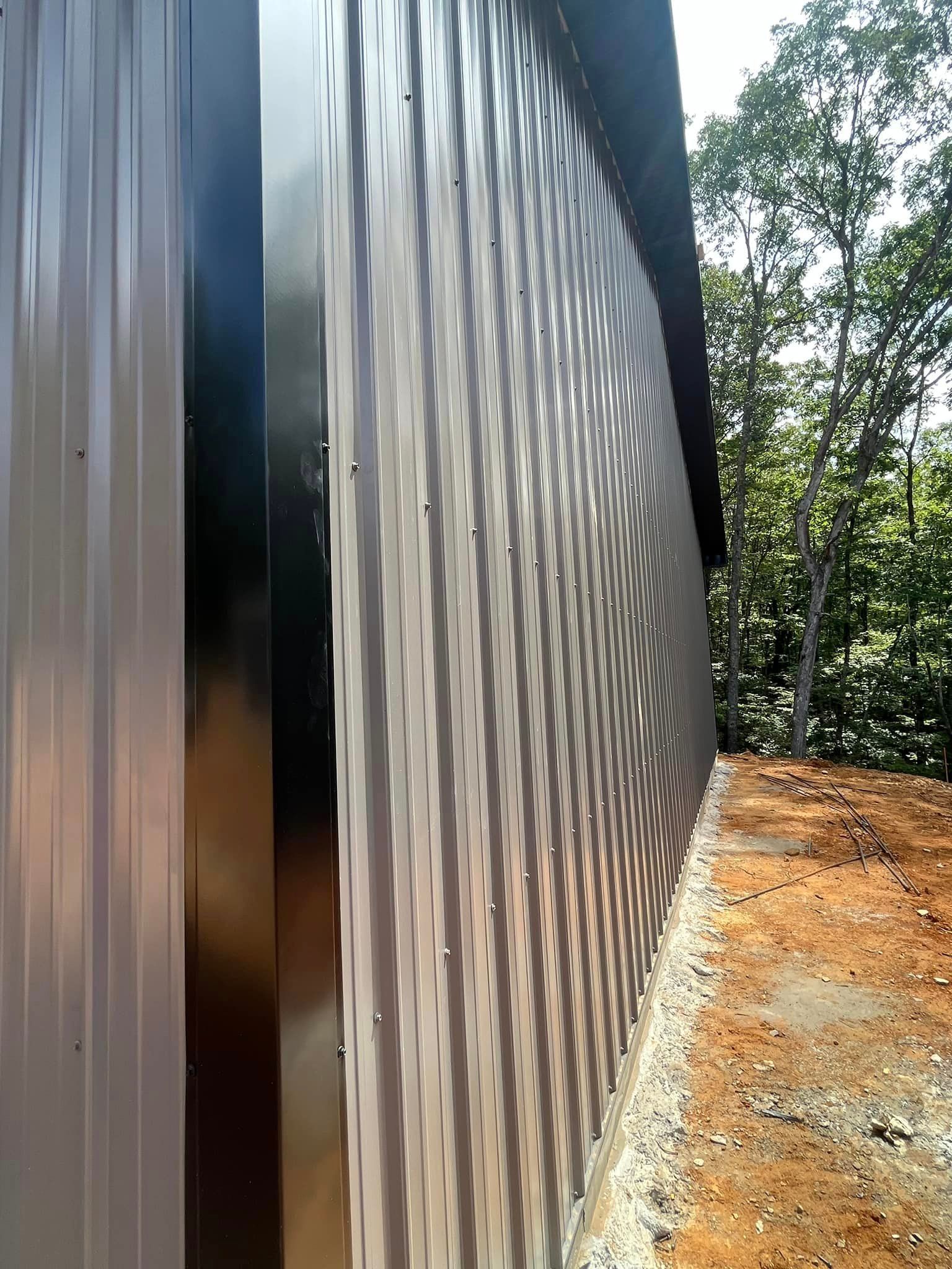 A large metal wall is sitting on top of a dirt hill.