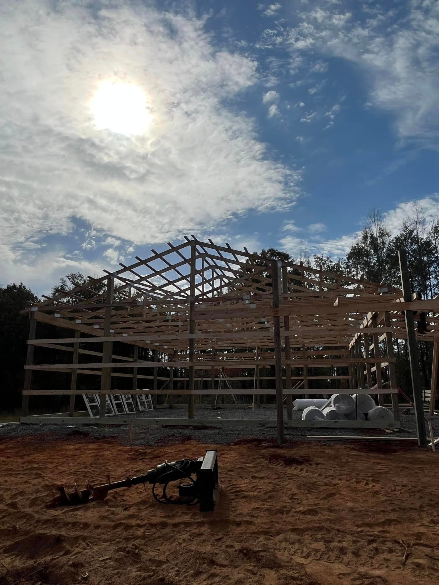 A large wooden structure is being built in the middle of a dirt field.