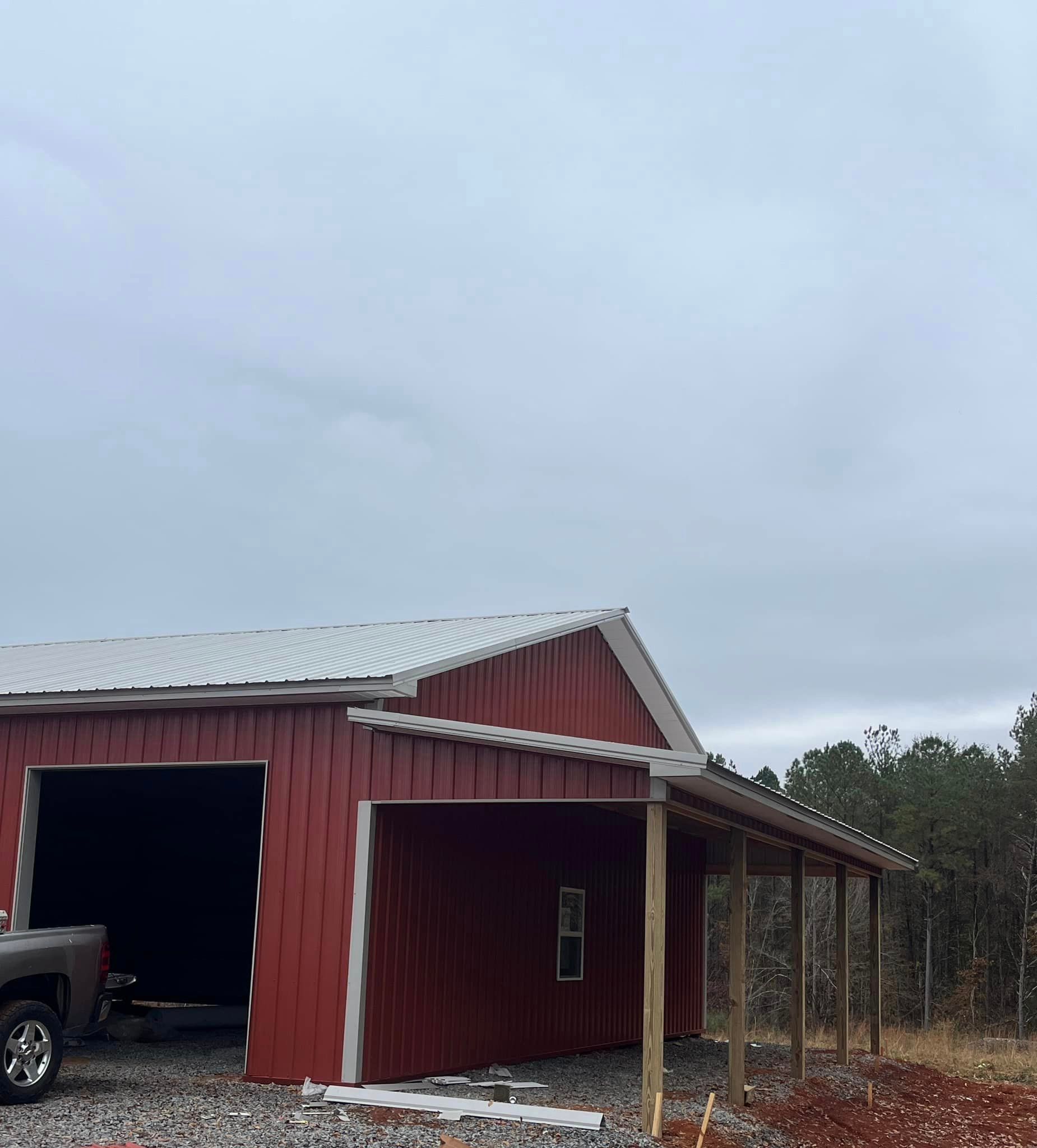 A red barn with a truck parked in front of it