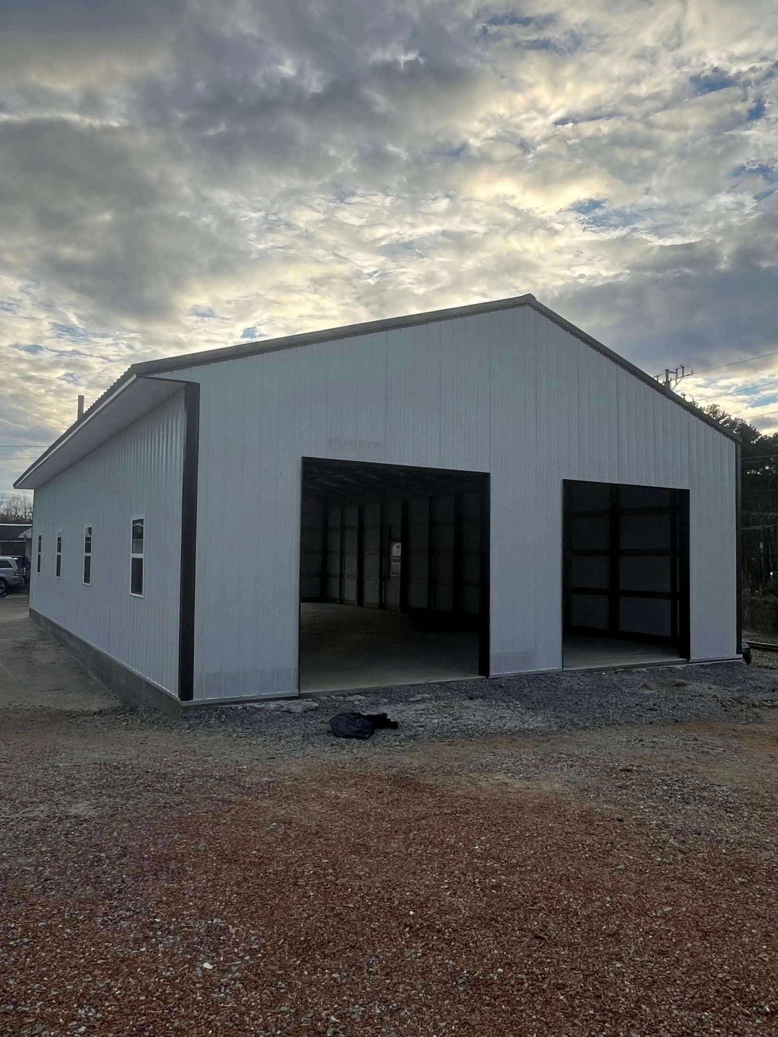 A large white building with two garage doors is being built.