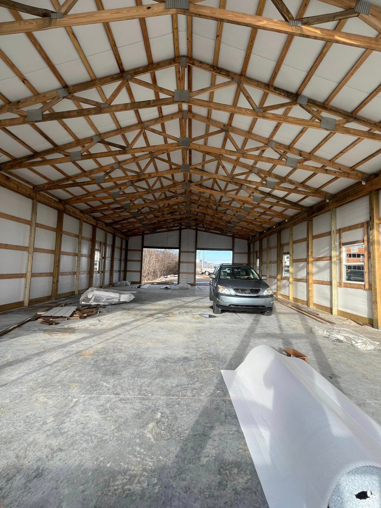 A car is parked inside of a building under construction.