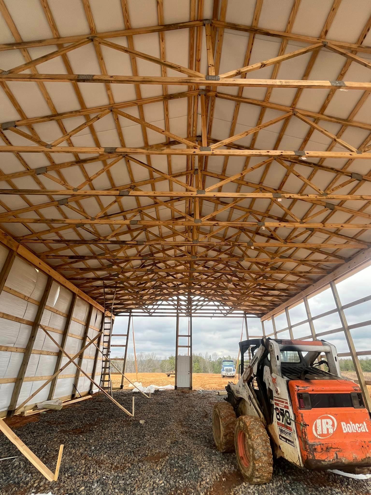 A bulldozer is parked inside of a building under construction.