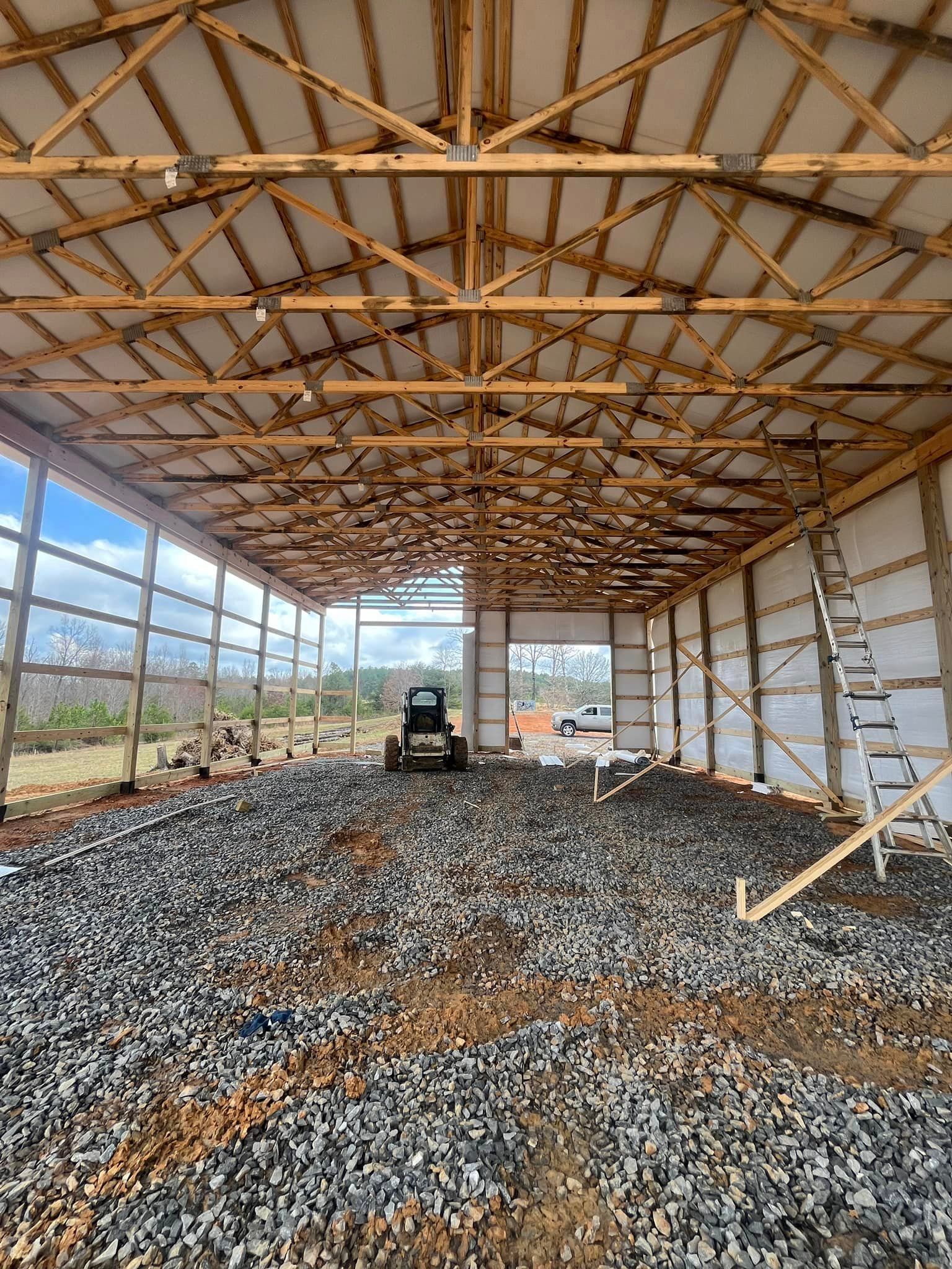 A tractor is parked inside of a building under construction.