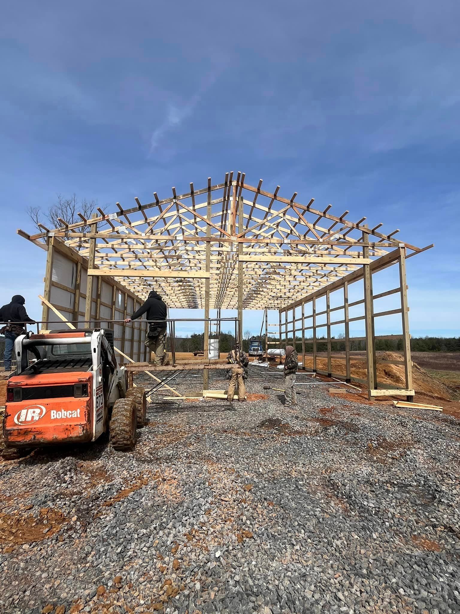 A bobcat is parked in front of a building under construction.