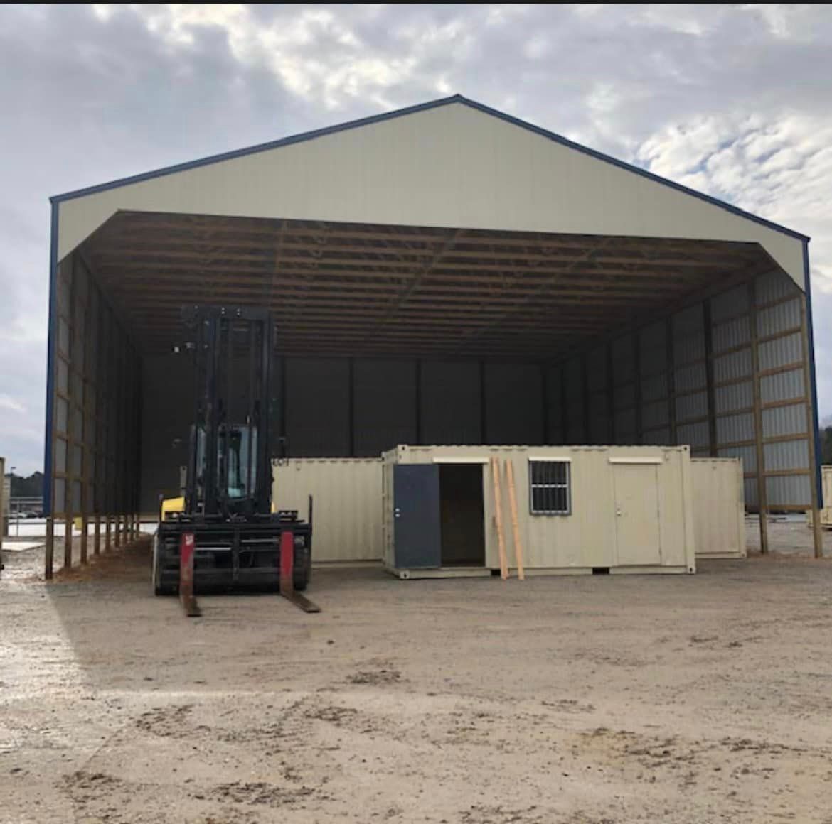 A forklift is parked in front of a large building