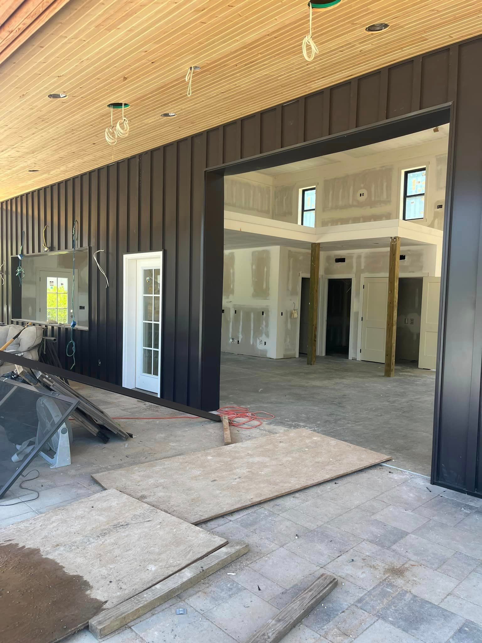 The inside of a building under construction with a large sliding glass door.
