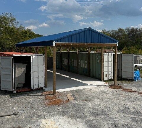 A row of shipping containers under a blue roof