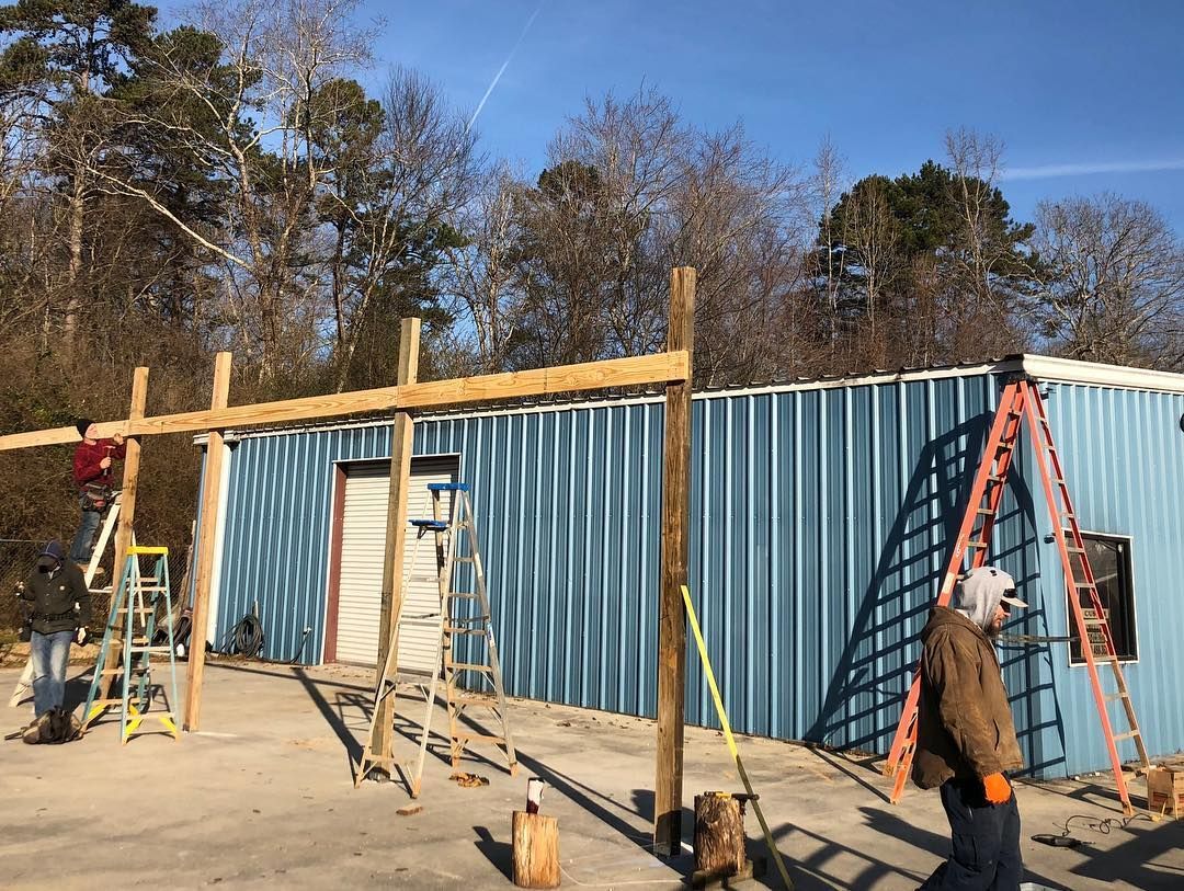 A man is walking in front of a blue building under construction.