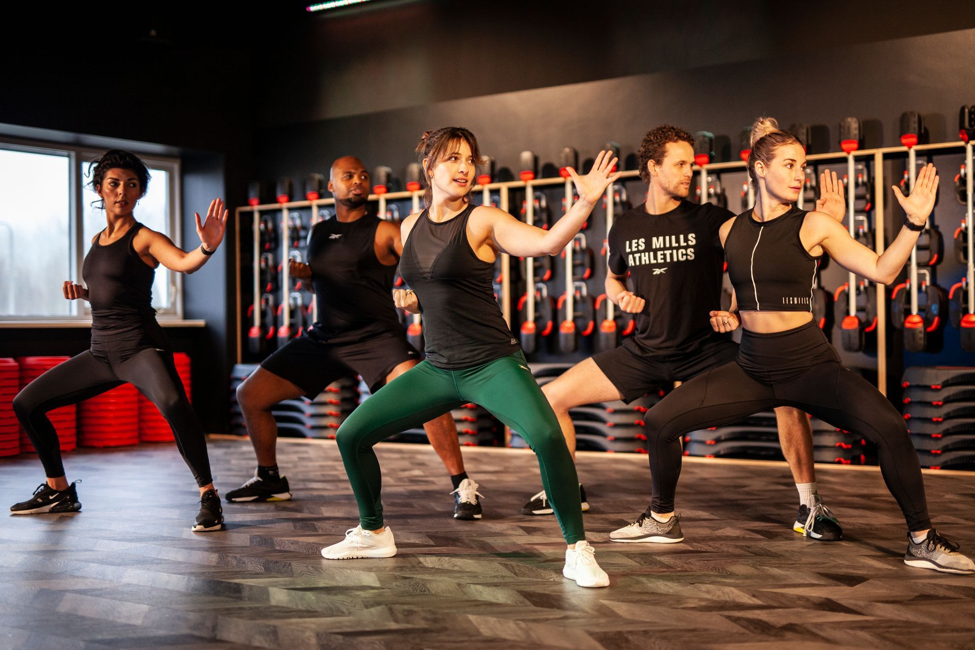 Een groep mensen danst in een gymzaal.
