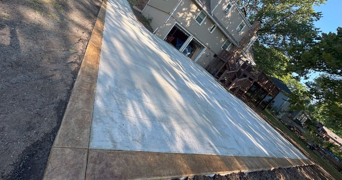 A concrete driveway is being built in front of a house.