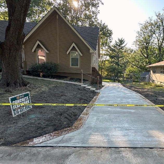 A concrete driveway is being built in front of a house