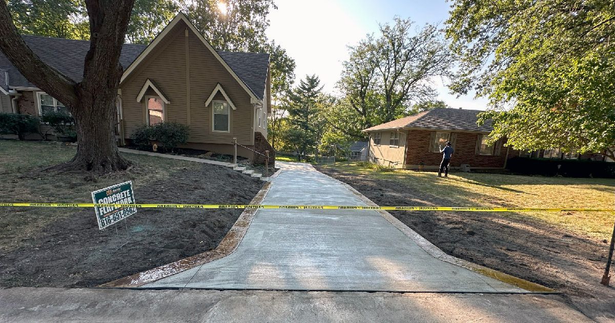 A concrete driveway is being built in front of a house.