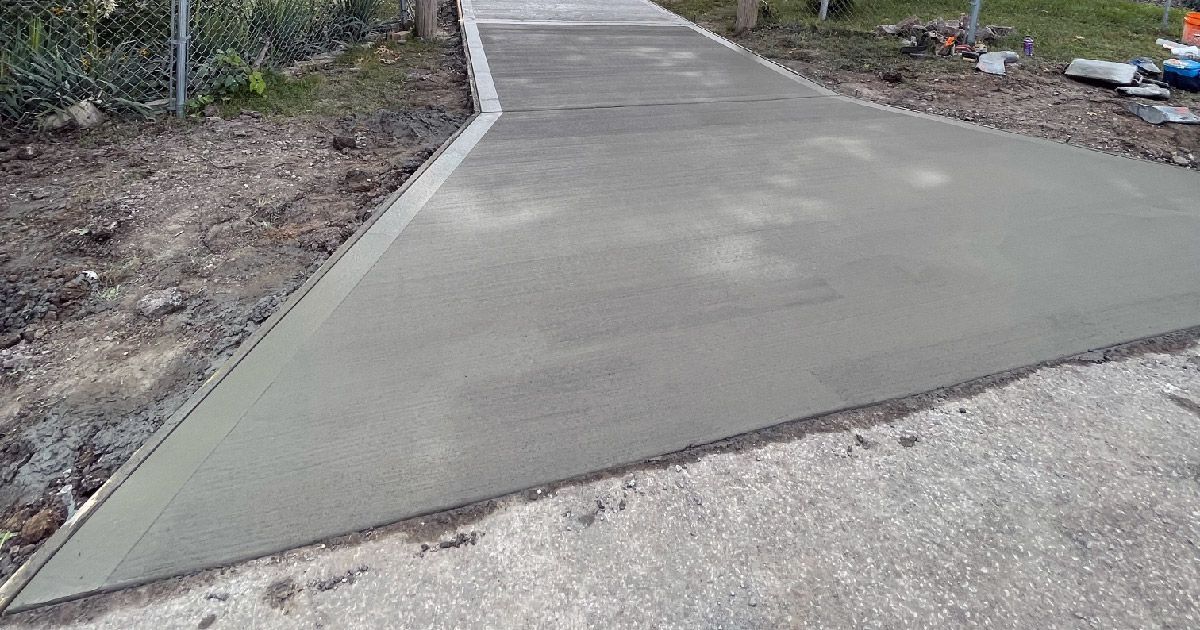 A concrete walkway is being built on the side of a road.