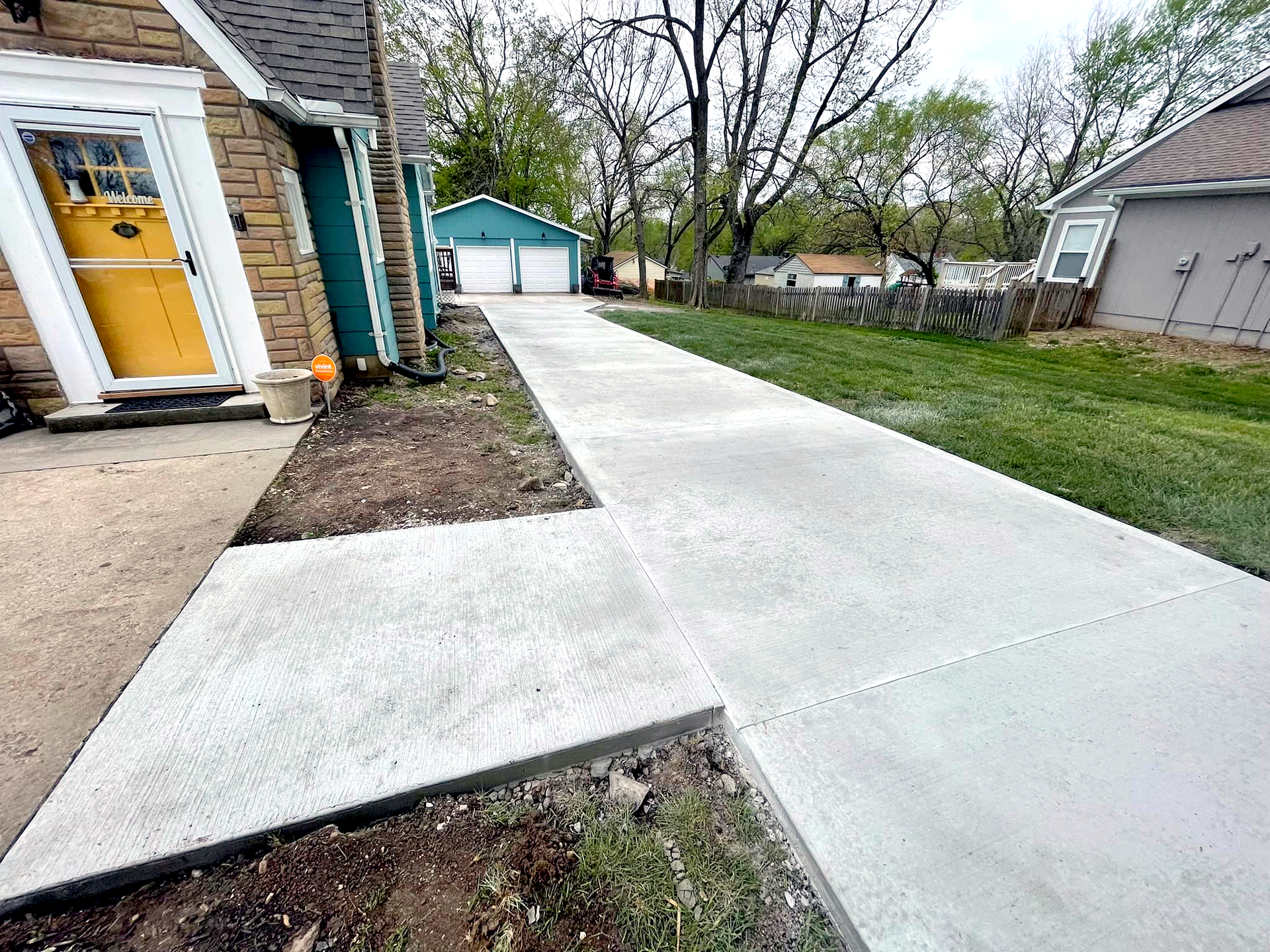 Residential driveway leading up to green shed