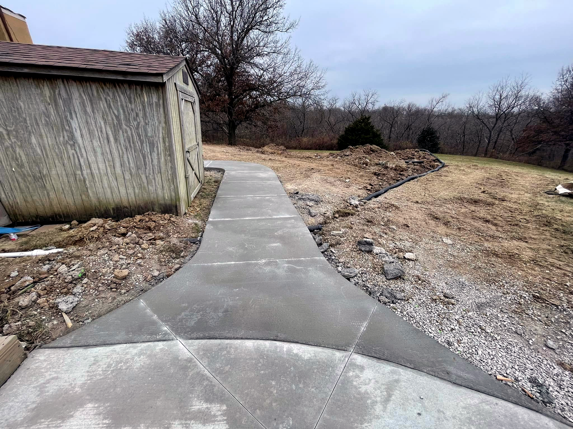 Rural concrete sidewalk next to a barn
