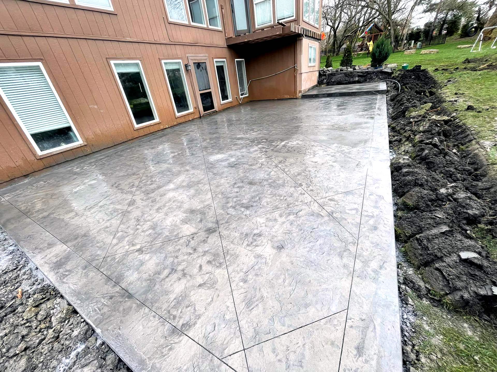 Stamped and sealed grey back concrete patio