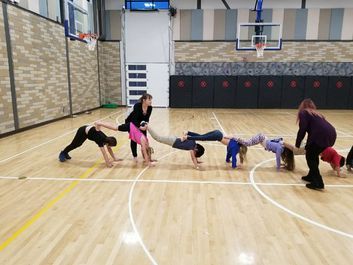 June guiding a group of children in a
“downward dog” yoga chain