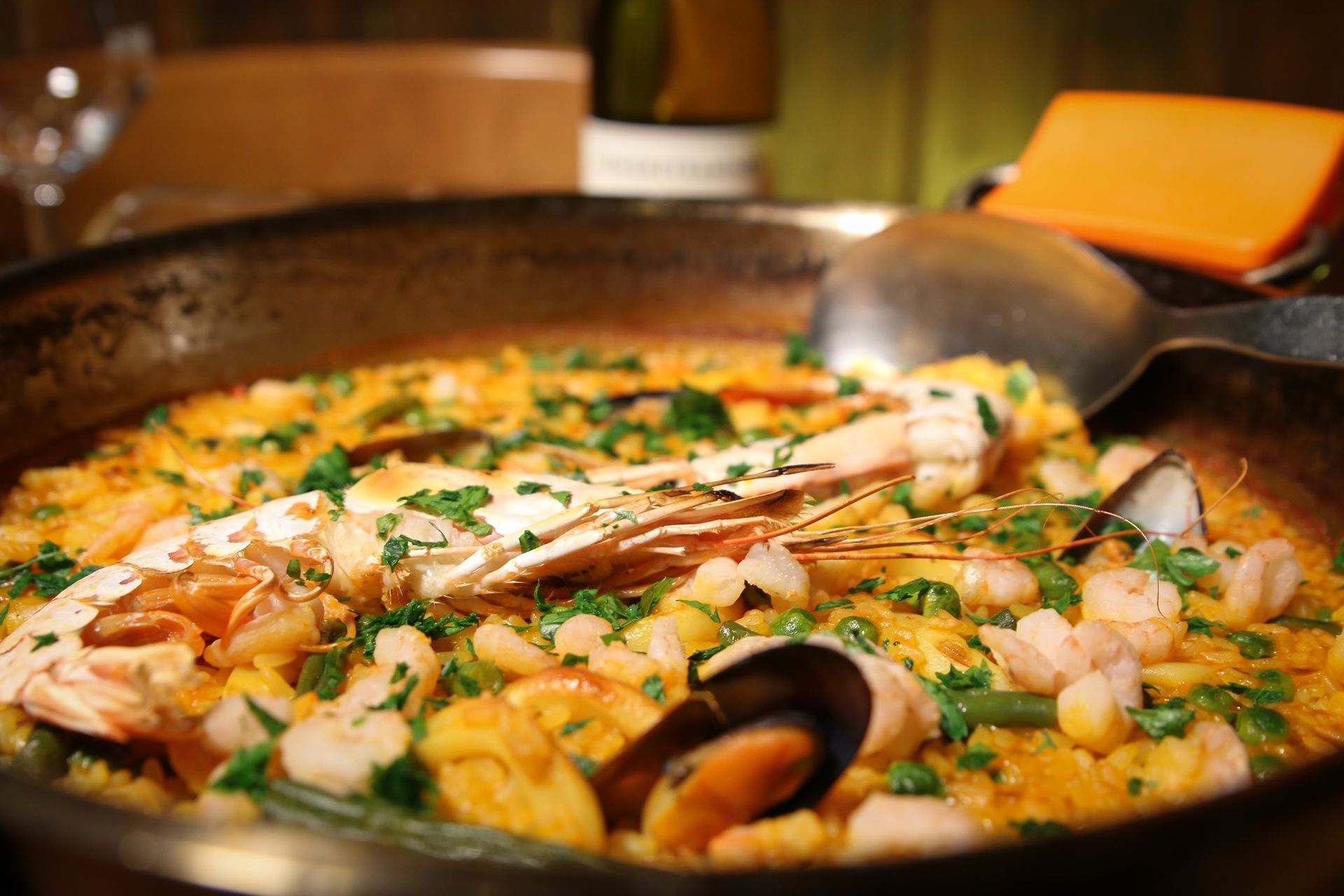 Una padella di paella di frutti di mare con un cucchiaio dentro.