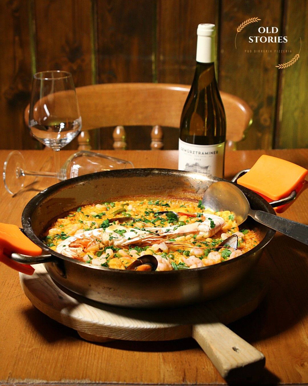 Una bottiglia di vino è appoggiata su un tavolo accanto a una pentola di cibo