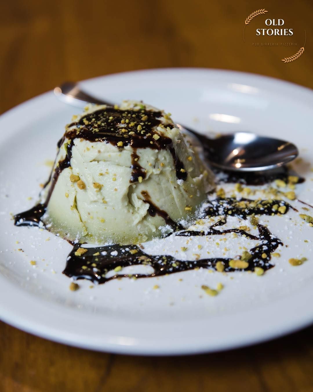 Un piatto bianco sormontato da un dolce e un cucchiaio.