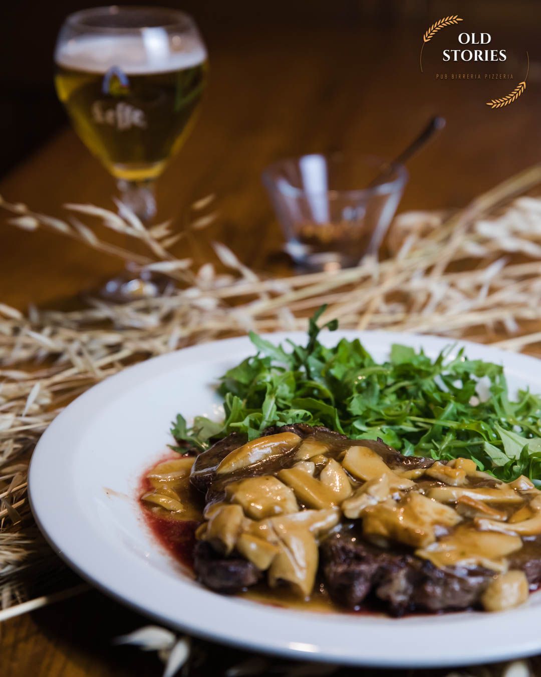 Un piatto di cibo con un bicchiere di birra sullo sfondo