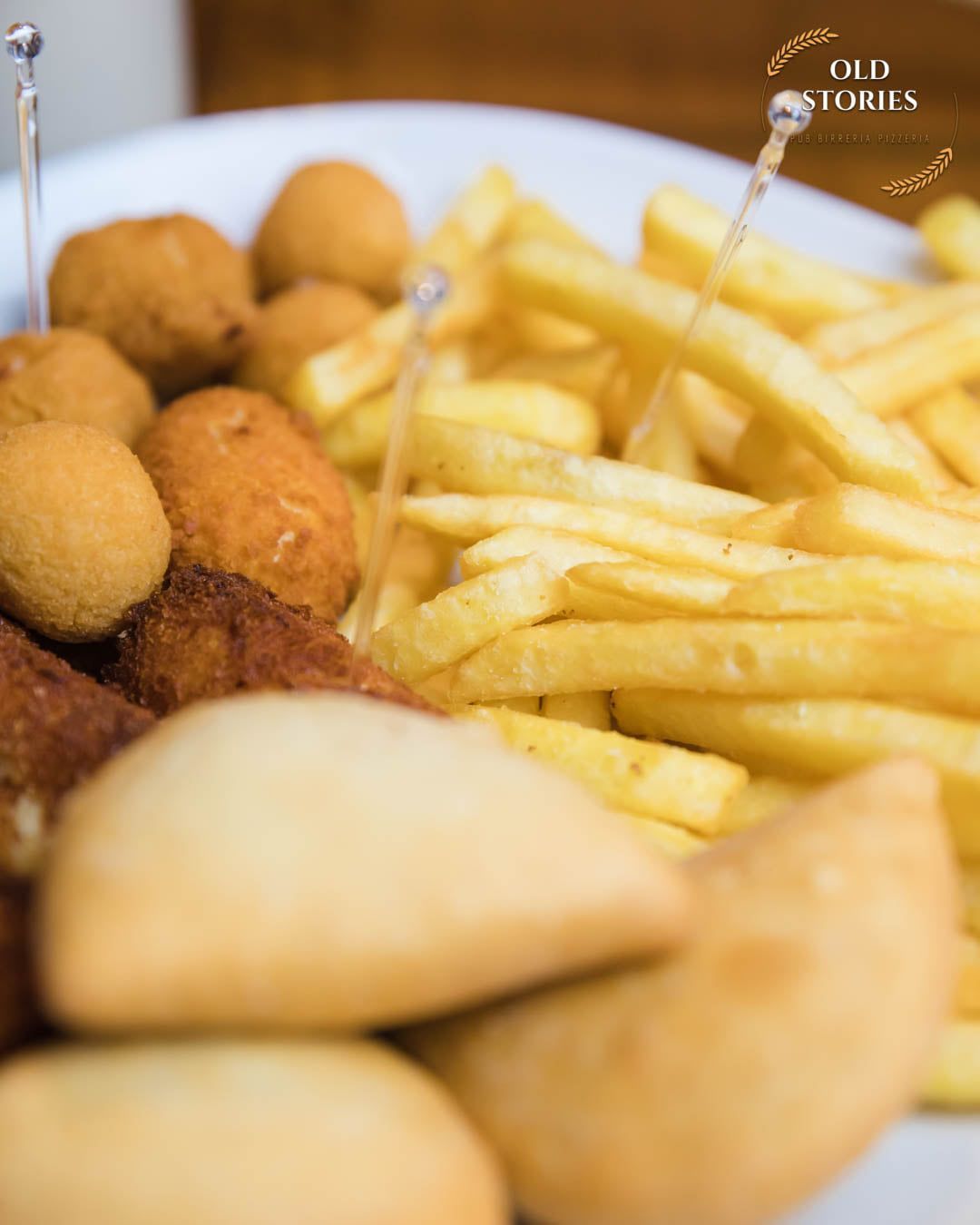 Un piatto bianco con patatine fritte e cibo fritto