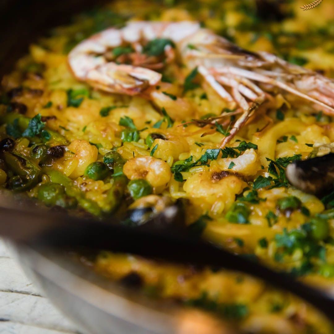 Un primo piano di una padella con cibo con gamberi e verdure
