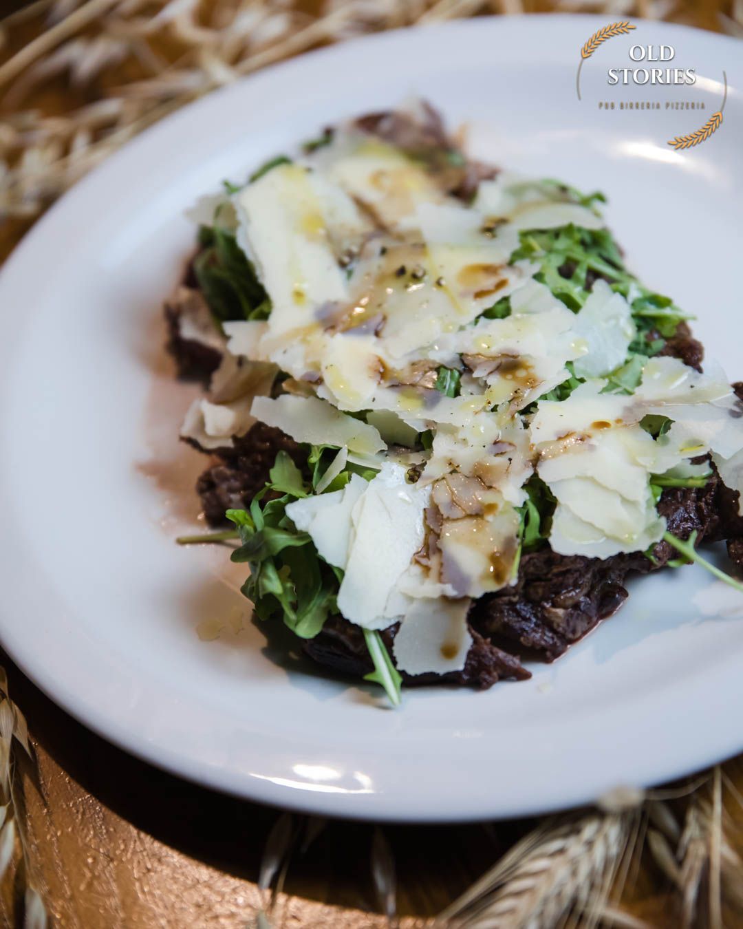 Un piatto bianco condito con un'insalata di carne e formaggio