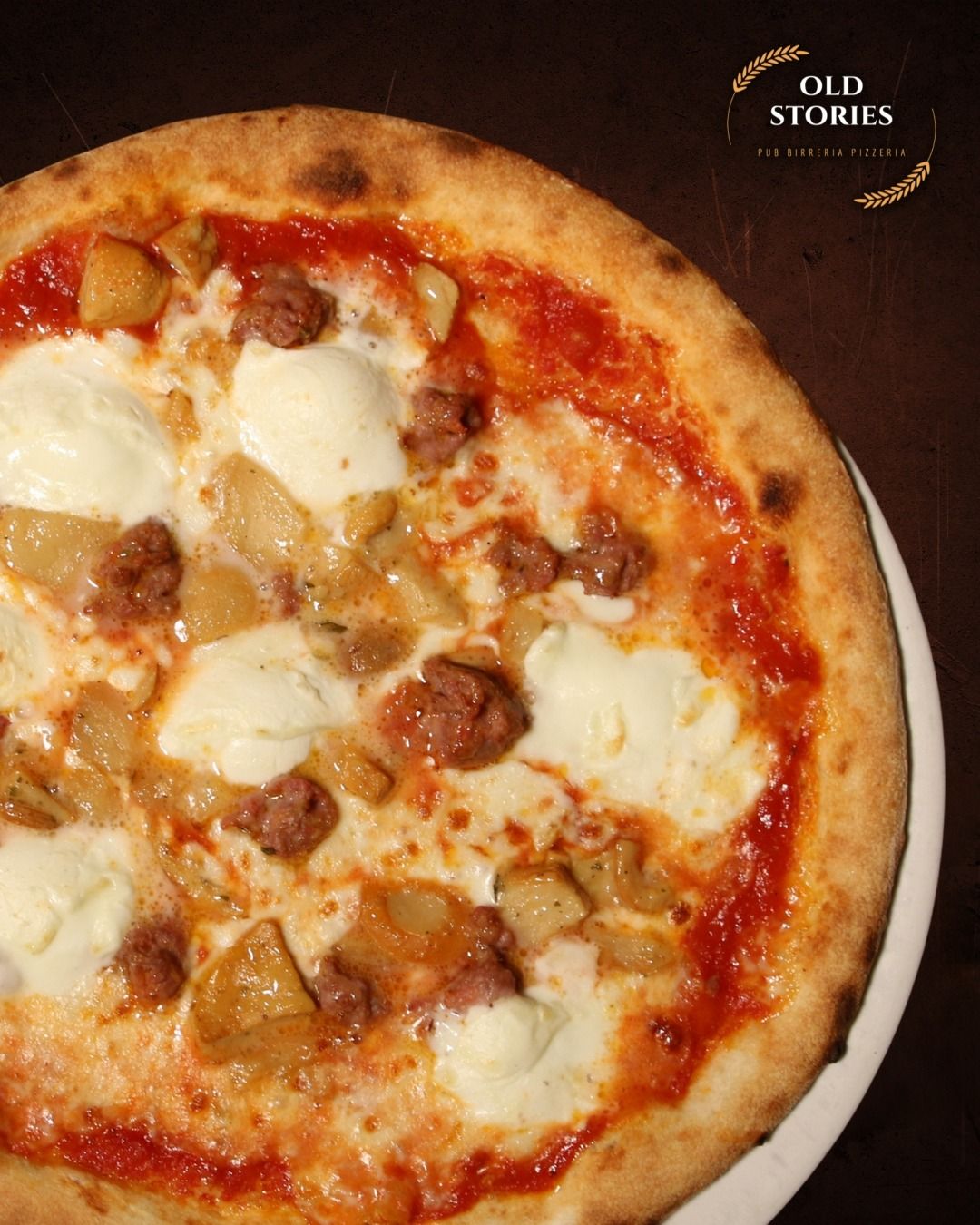 Pizza con salsiccia, mozzarella e salsa, su un piatto bianco.