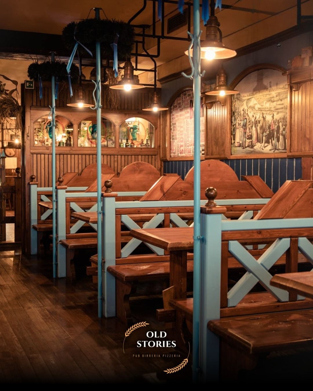 Separé in legno in un pub, dettagli blu, luci soffuse, arredamento vecchio stile.