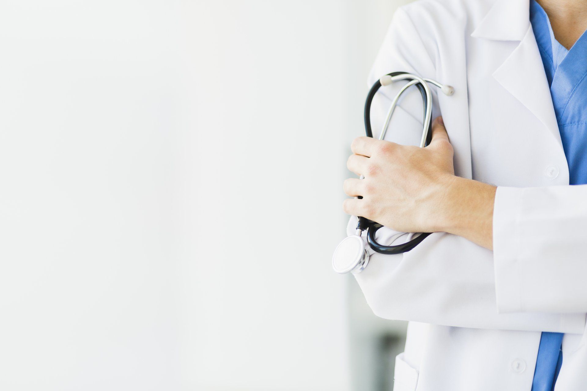 Un médico sostiene un estetoscopio en sus manos.