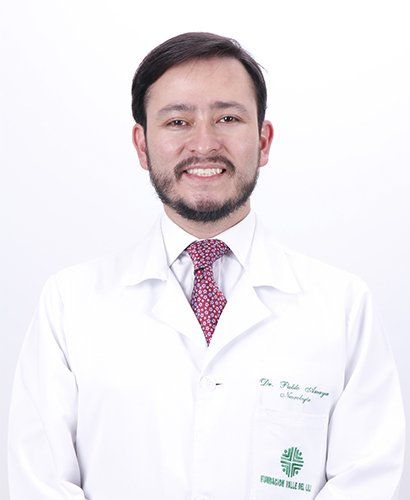 Un hombre con barba lleva una bata de laboratorio blanca y corbata.