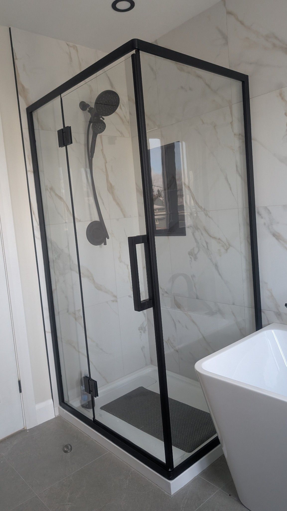 Une salle de bain avec une cabine de douche et une baignoire.