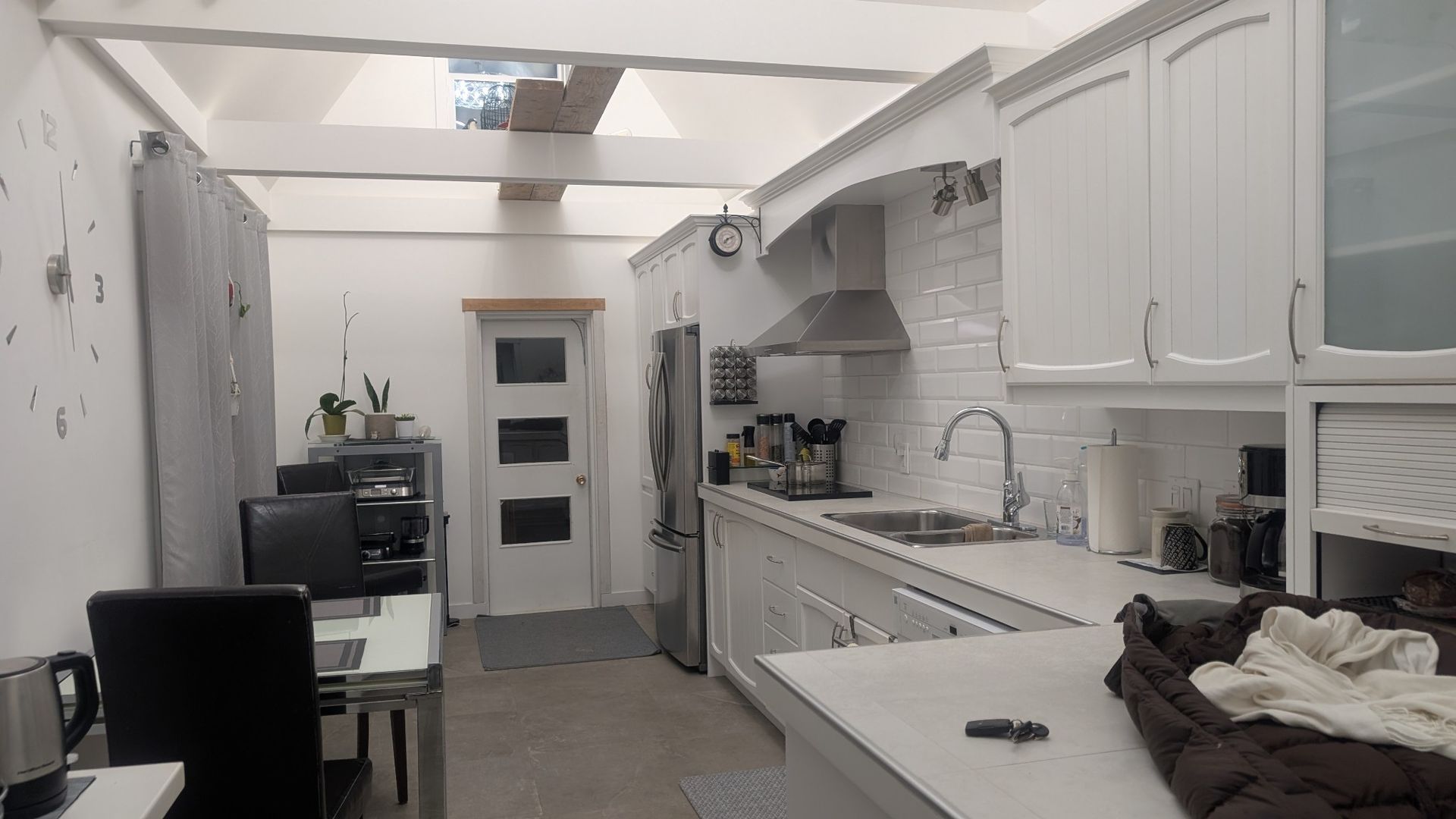 Une cuisine avec des armoires blanches et un évier.