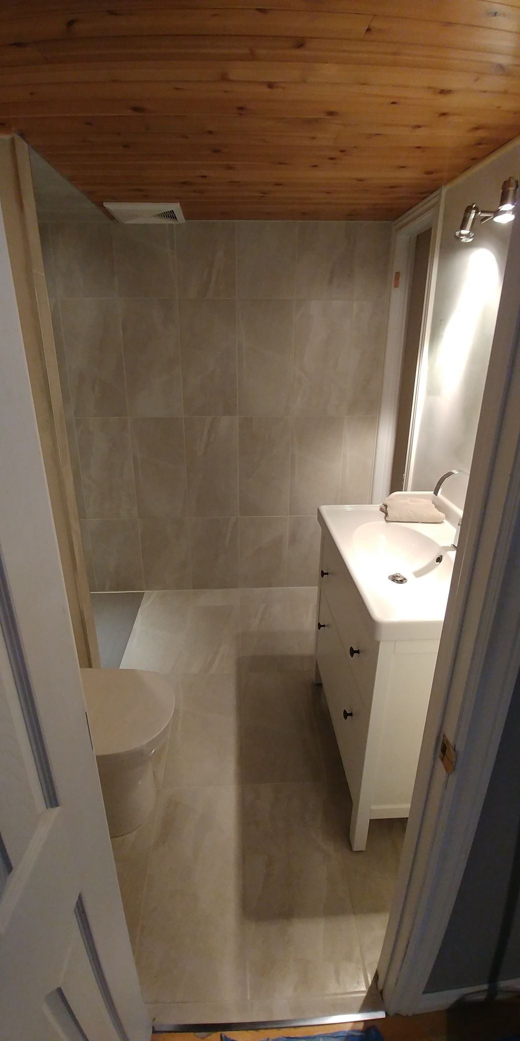 Une salle de bain avec lavabo, miroir et douche.